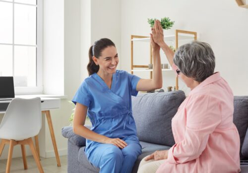 Cheerful,Positive,Female,Nurse,Giving,High,Five,To,Her,Senior